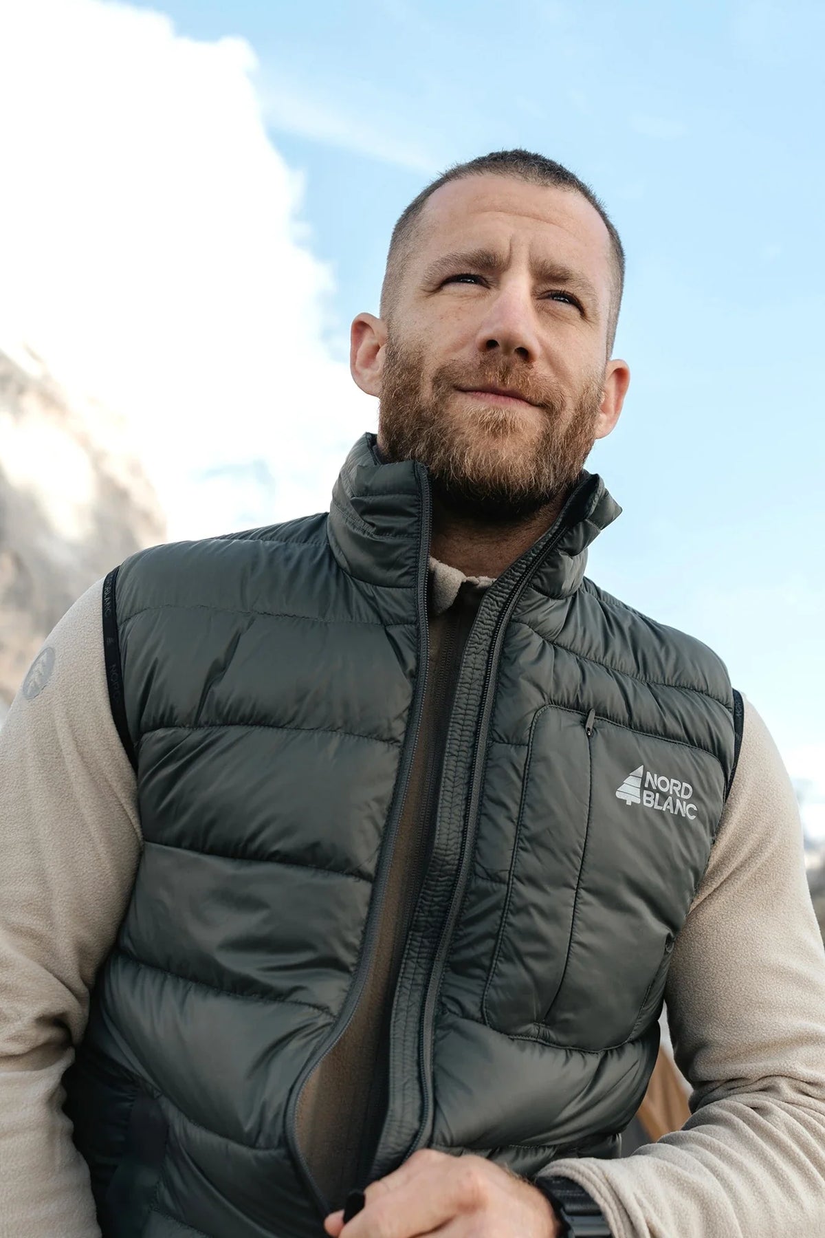 Man in a green winter gilet in the mountains